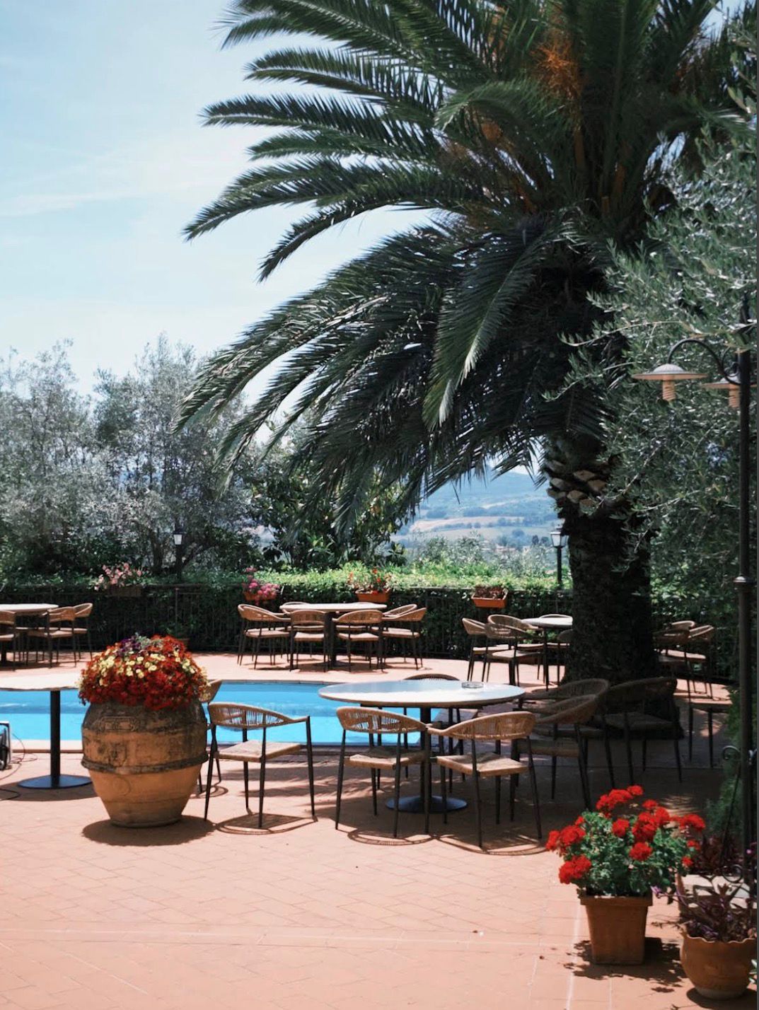 Terrazza sulla piscina con tavoli e vista sulle colline umbre
